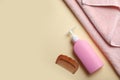 Bottle with shampoo, towel and comb on color background, flat lay.