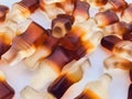 The bottle-shaped marmalade is in a small, round and transparent plate. gelatinous mouth-watering sweets. macro photography.