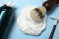 Bottle of shaving foam, brush and razor on light blue background, flat lay Royalty Free Stock Photo