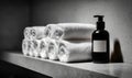 A bottle of soap is on a shelf next to a stack of white towels Royalty Free Stock Photo