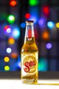 A Bottle of Sol Beer. A Mexican beer on a white texture surface on a colourful defocused lights
