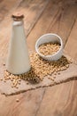 A bottle of soy milk or soya milk and soy beans on wooden table. Royalty Free Stock Photo