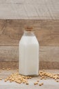 Bottle of soy milk and soybean on wooden table Royalty Free Stock Photo