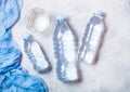 Bottle of sparkling mineral water with glass of ice and blue cloth on white Royalty Free Stock Photo