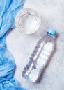 Bottle of sparkling mineral water with glass of ice and blue cloth on white Royalty Free Stock Photo