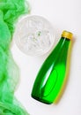 Bottle of sparkling mineral water with glass of ice and green cloth on white Royalty Free Stock Photo