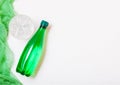 Bottle of sparkling mineral water with glass of ice and green cloth on white Royalty Free Stock Photo