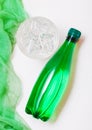 Bottle of sparkling mineral water with glass of ice and green cloth on white Royalty Free Stock Photo