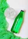 Bottle of sparkling mineral water with glass of ice and green cloth on white Royalty Free Stock Photo