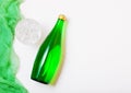 Bottle of sparkling mineral water with glass of ice and green cloth on white Royalty Free Stock Photo