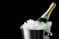 Bottle of sparkling wine in cooler bucket on black background, closeup. Space for text Royalty Free Stock Photo