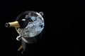 Bottle of sparkling wine in cooler bucket on black mirror surface, above view. Space for text Royalty Free Stock Photo