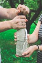 A bottle of sparkling wine in hands, a pair opens a bottle