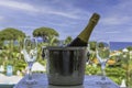 A bottle of sparkling wine in an ice bucket and two glasses on the balcony against the background of the sea and the Royalty Free Stock Photo