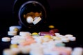 A bottle of spilled pills on black background.Levitating tablets. Tablets on a dark background that are falling. Tablets. Medicine