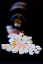 A bottle of spilled pills on black background.Levitating tablets. Tablets on a dark background that are falling. Tablets. Medicine