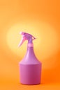 Bottle with spray on orange background/purple spray bottle isolated on orange background Royalty Free Stock Photo