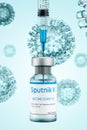 Bottle of Sputnik V vaccine for COVID-19 coronavirus infection. The syringe is gaining a dose of injection against the background