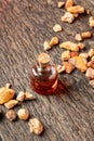 A bottle of styrax benzoin essential oil with benzoin resin on a table Royalty Free Stock Photo