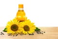 Bottle of sunflower oil with flowers and seed of sunflower on the wooden table on white background with space for text Royalty Free Stock Photo