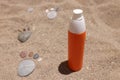 Bottle of sunscreen lotion sits on hot sand