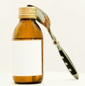 Bottle with suspention and tea-spoon Royalty Free Stock Photo