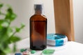 Bottle of syrup, dosing spoon and pills on shelf. Cold medicine Royalty Free Stock Photo