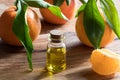 A bottle of tangerine essential oil on a wooden background Royalty Free Stock Photo