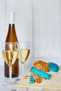 Bottle and two glasses of white wine, white grape and variation of ucommon cheeses on a wooden background Royalty Free Stock Photo