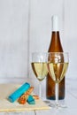 Bottle and two glasses of white wine, white grape and variation of ucommon cheeses on a wooden background Royalty Free Stock Photo