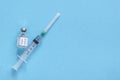 Bottle with vaccine and medicine syringe with vaccine on blue background. Concept of vaccination and healthcare Royalty Free Stock Photo