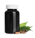 Bottle with vitamin capsules and green leaves Royalty Free Stock Photo