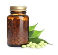Bottle with vitamin pills and green leaves Royalty Free Stock Photo