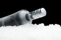 Bottle of vodka lying on ice on black background Royalty Free Stock Photo