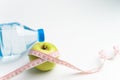 Bottle of water, apple and measuring tape isolated on white background