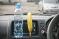 A bottle of water and a banana in the car, a healthy eating concept.