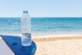 Bottle of water on beach table under open sky on background of sea Royalty Free Stock Photo