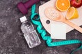 bottle of water, dumbbells, measuring tape, diet food on a black background Royalty Free Stock Photo