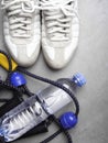 Bottle of water, expander, sport shoes on grey background