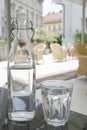 Bottle of water and glass on table in italian style restaurant