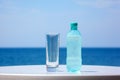 Bottle of water and glass on table under open sky Royalty Free Stock Photo