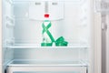 Bottle of water with measuring tape on shelf of open empty refrigerator