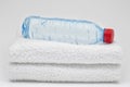 Bottle of water and towels. On grey background Royalty Free Stock Photo