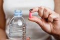 A bottle of water in woman hand tablet in other hand Royalty Free Stock Photo