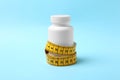 Bottle of weight loss pills with measuring tape Royalty Free Stock Photo