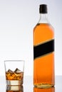 Bottle of whiskey and glass with ice