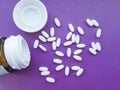 Bottle and white medical pills on a violet background Royalty Free Stock Photo