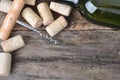 Bottle of white wine, corkscrew and corks on wooden table.