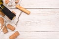 Bottle of white wine, corkscrew and corks on wooden table. Royalty Free Stock Photo