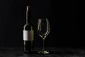 A bottle of white wine and a glass on a black background. Royalty Free Stock Photo